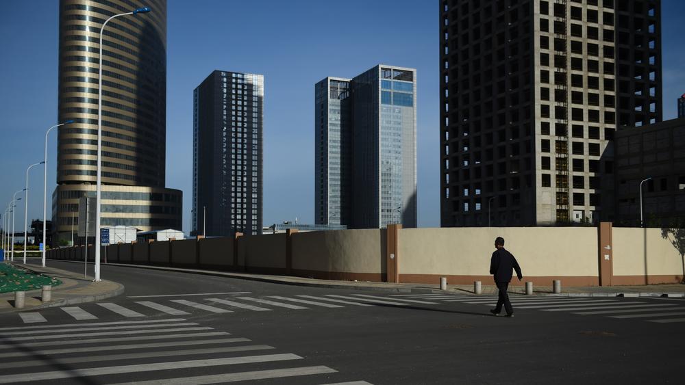 A man walks in an empty street in Conch Bay opposite the new Yujiapu Financial District in Tianjin, China, in 2015.
