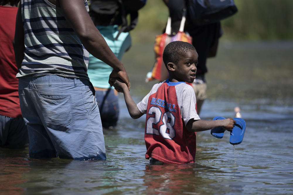 A child looks back as he crosses the Rio Grande.