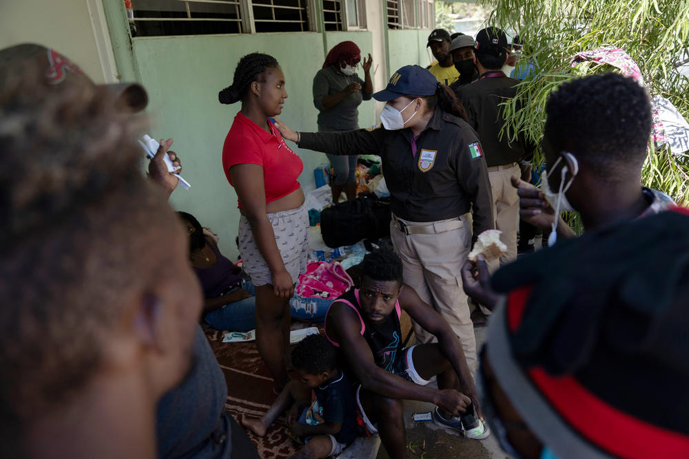 A Mexican immigration officer talks with migrants.