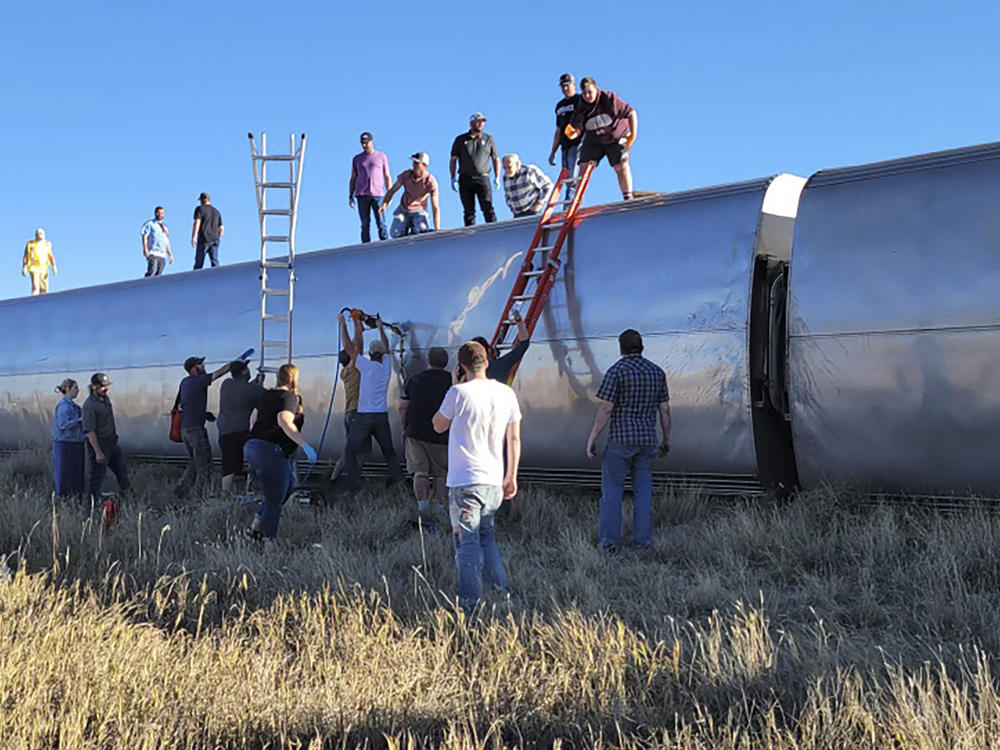 In this photo provided by Kimberly Fossen, people work at the scene of an Amtrak train derailment on Saturday in north-central Montana. Multiple people were injured when the train that runs between Seattle and Chicago derailed Saturday, the train agency said.