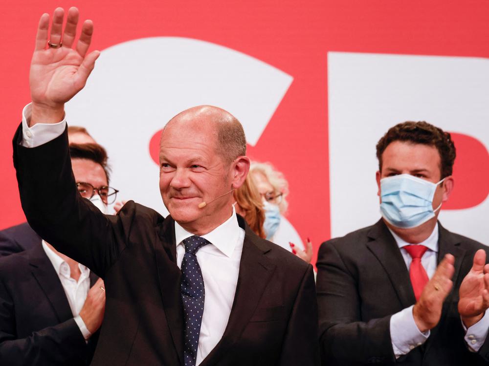German SPD candidate for chancellor Olaf Scholz waves on stage at the Social Democratic Party (SPD) headquarters after the estimates were broadcast in Berlin on Sunday.