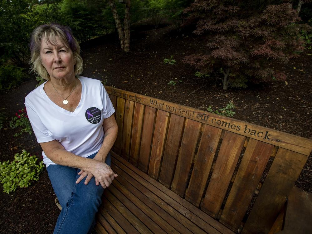 Lynn Wencus sits on a bench in her backyard dedicated to her son Jeff, whom she lost to an opioid overdose in 2017. She is one of many people filing an individual claim in the Purdue Pharma settlement.
