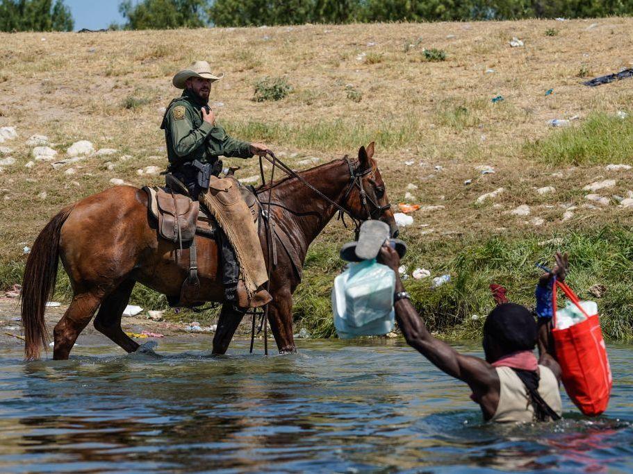 A U.S. Border Patrol agent on horseback tries to stop a Haitian migrant from entering an encampment on the banks of the Rio Grande in Del Rio, Texas. The Department of Homeland Security has pledged an investigation into the matter.