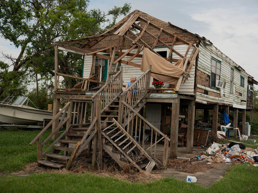 Annie Parfait, a Houma Nation elder, sits outside her home in Dulac, La., on Sept. 21, three weeks after Hurricane Ida made landfall in southeast Louisiana. Parfait, 70, rode out the storm at the Houma Nation Headquarters in Houma, La.