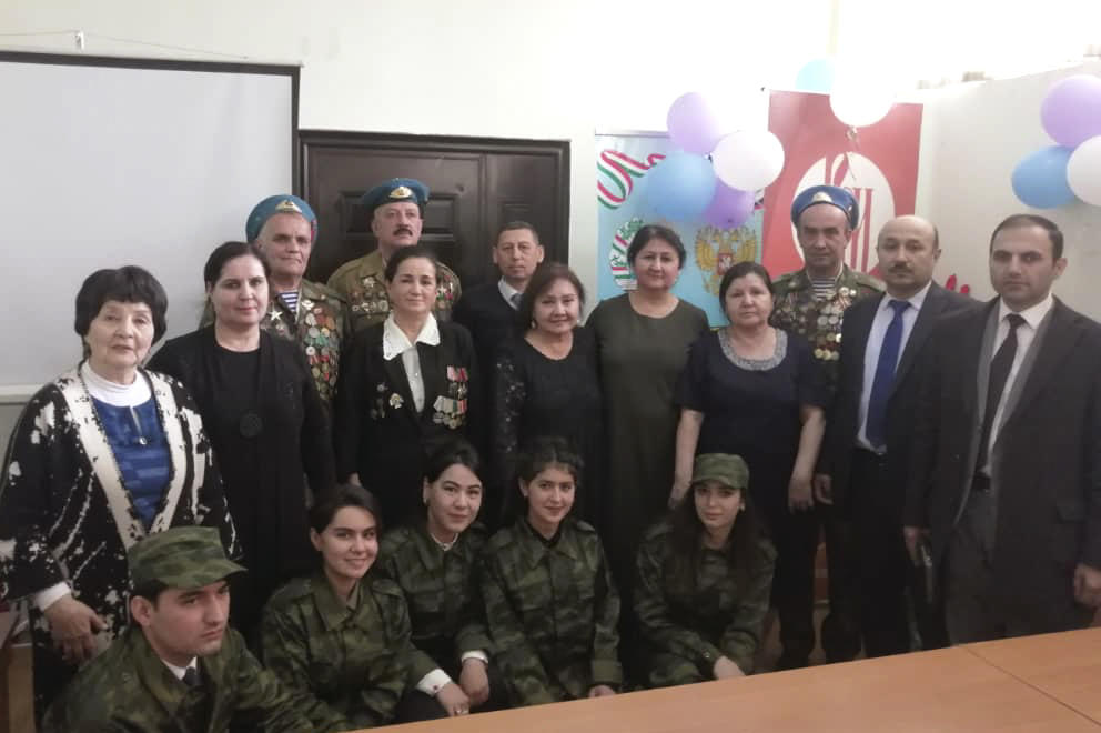 Rustam Khodzhayev (in back row with mustache) and Mukhru Khodzhayeva (in front of him with white collar) pose with young army cadets in Dushanbe, Tajikistan, in 2019. The couple is still active in veterans' affairs.
