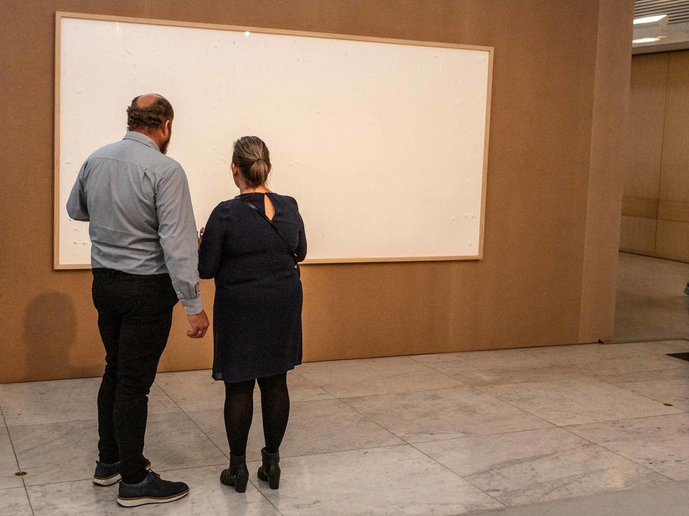 Visitors view a blank canvas that is part of 