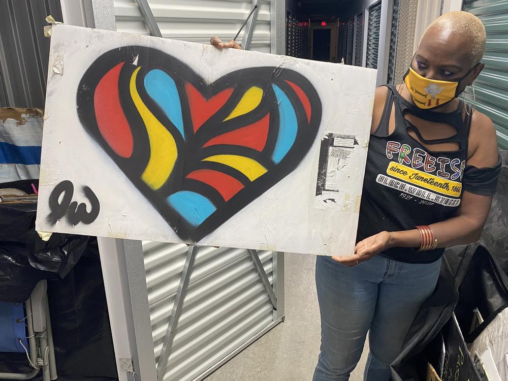 Nadine Seiler poses with a piece of artwork that was once displayed on the Black Lives Matter fence near the White House. Seiler is working to find new homes for the 700-plus artifacts left by protesters.
