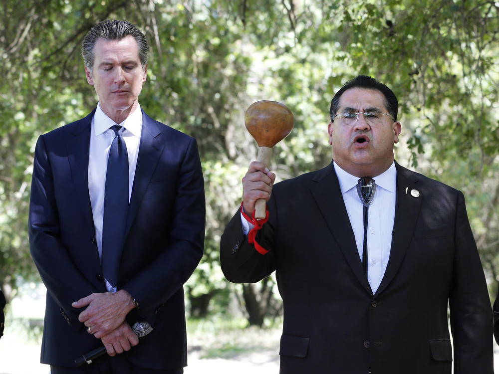 Gov. Gavin Newsom, left, bows his head as Assemblyman James Ramos opens a meeting with tribal leaders from around the state in 2019 in West Sacramento, Calif. In 2021, Ramos authored, and Newsom signed, a law to erect a monument to Native Americans in Sacramento outside the state capitol.