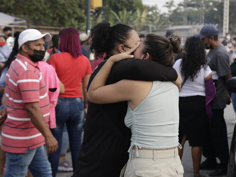 Women hug while waiting for some information about their relatives who are inmates at Litoral Penitentiary, after a prison riot, in Guayaquil, Ecuador, Wednesday. The authorities report at least 100 dead and 52 injured in the riot which began Tuesday at the prison.