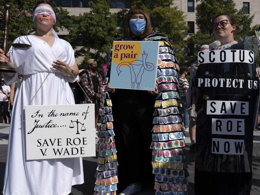 Activists hold signs during the Women's March rally at Freedom Plaza in Washington on Saturday.