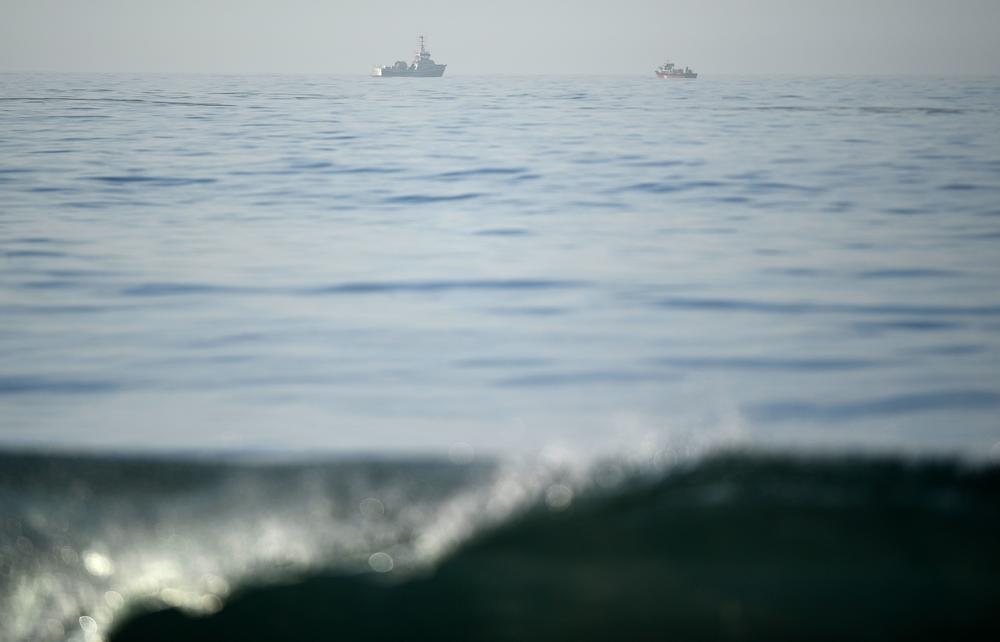 Boats helping clean up an oil spill are seen from the shore in Huntington Beach, California on October 3, 2021, after a pipeline breach connected to an oil rig off shore started leaking oil, according to an Orange County Supervisor.