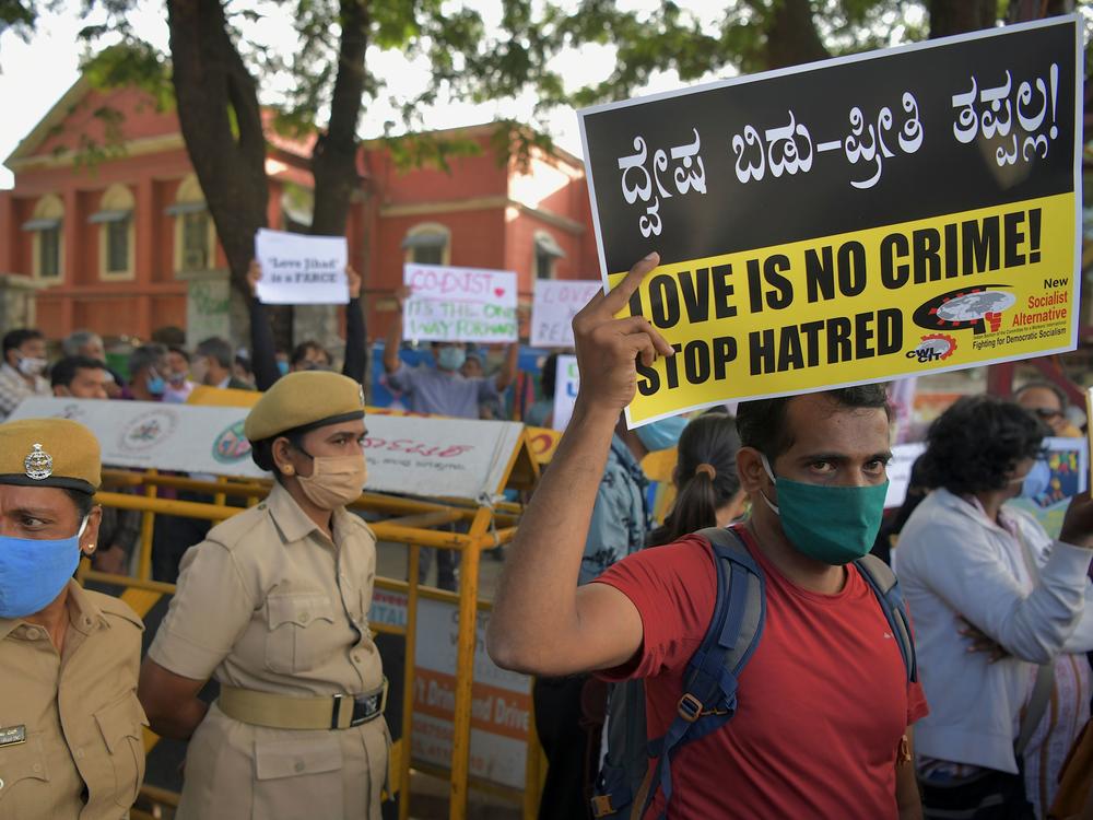 A civil rights activist holds a placard during a 2020 demonstration in Bengaluru, India, condemning the proposal in several states of laws against so-called 