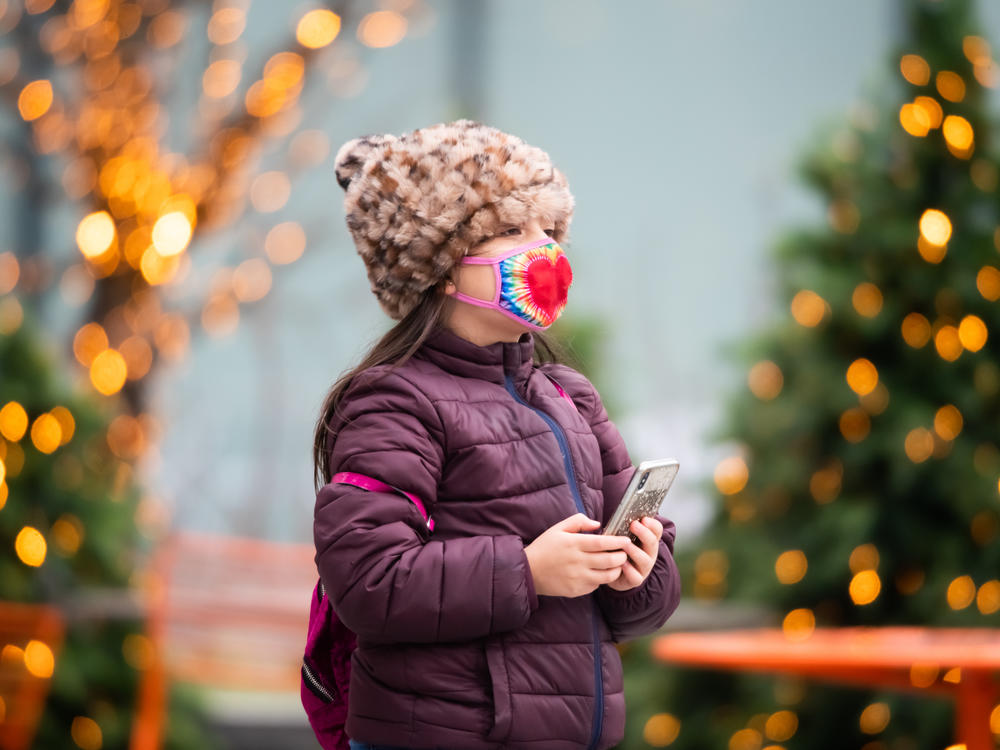 Above, a child walks by a Christmas display in New York City last year. Dr. Anthony Fauci, the nation's top infectious disease expert, says it's 