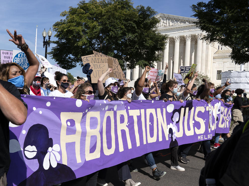 Thousands of demonstrators march outside the U.S. Supreme Court during the Women's March in Washington, Saturday, Oct. 2, 2021.