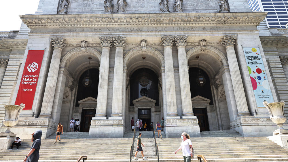 People walk along the stairs of the New York Public Library building on July 6 in Midtown Manhattan in New York City.