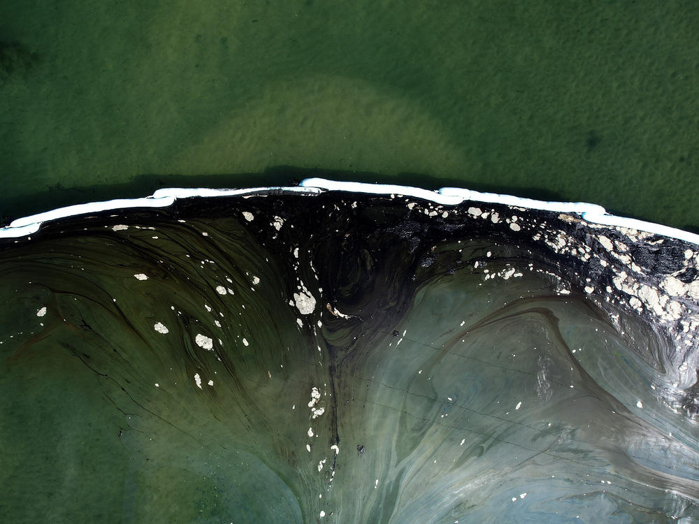 A floating barrier known as booms is set up to try to stop further incursion into the Wetlands Talbert Marsh after an oil spill in Huntington Beach, Calif., last week.