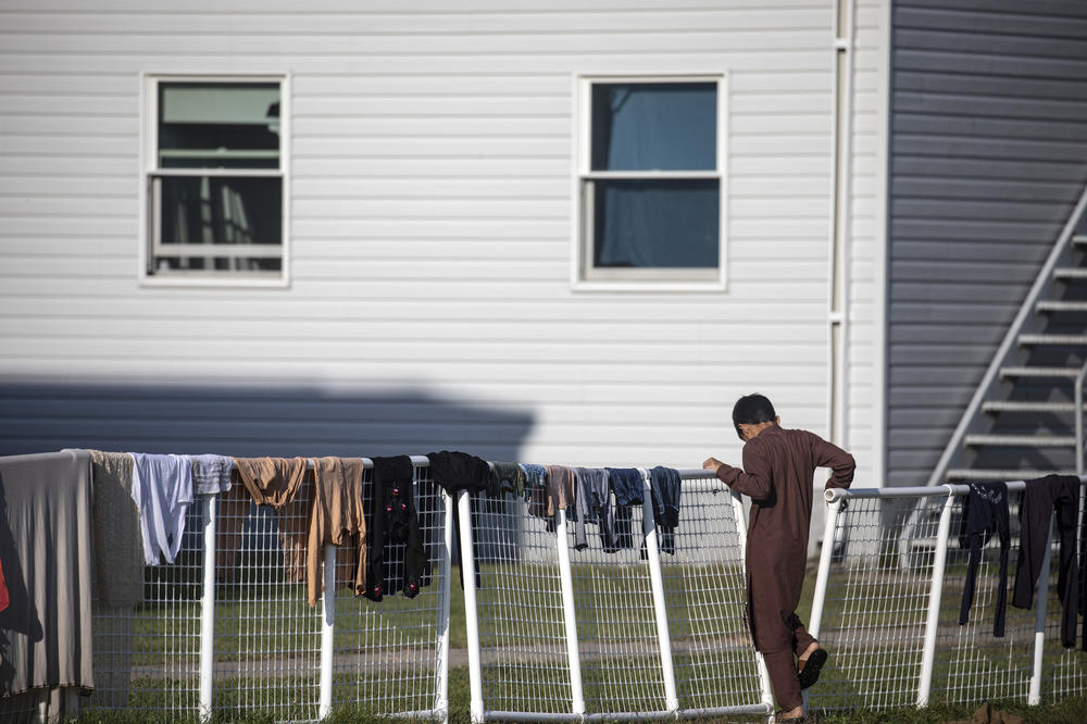 An Afghan refugee stands outside temporary housing at Fort McCoy.