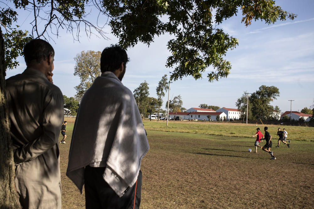 Members of the U.S. military and Afghan refugees play soccer at Fort McCoy in Wisconsin. There are nearly 13,000 Afghans at the base.