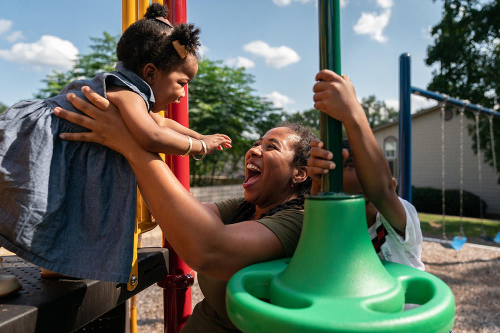 Akira Johnson plays with her daughter Shakira at the playground in their apartment community.