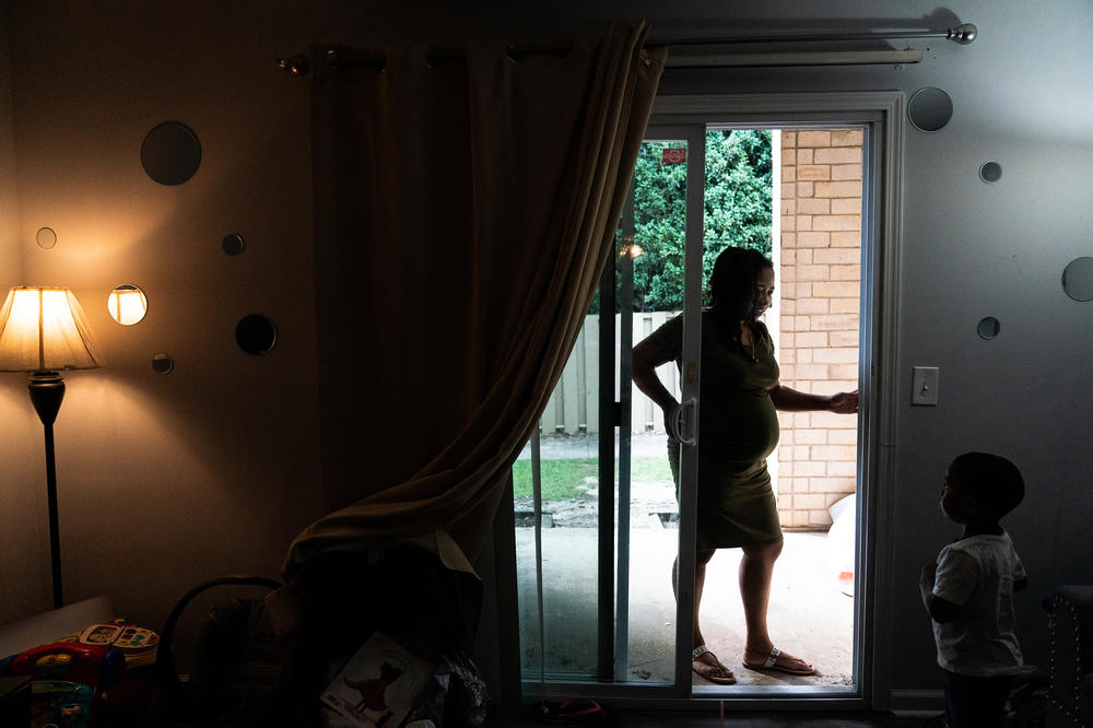 Akira Johnson talks to her son, Jason, in their apartment.