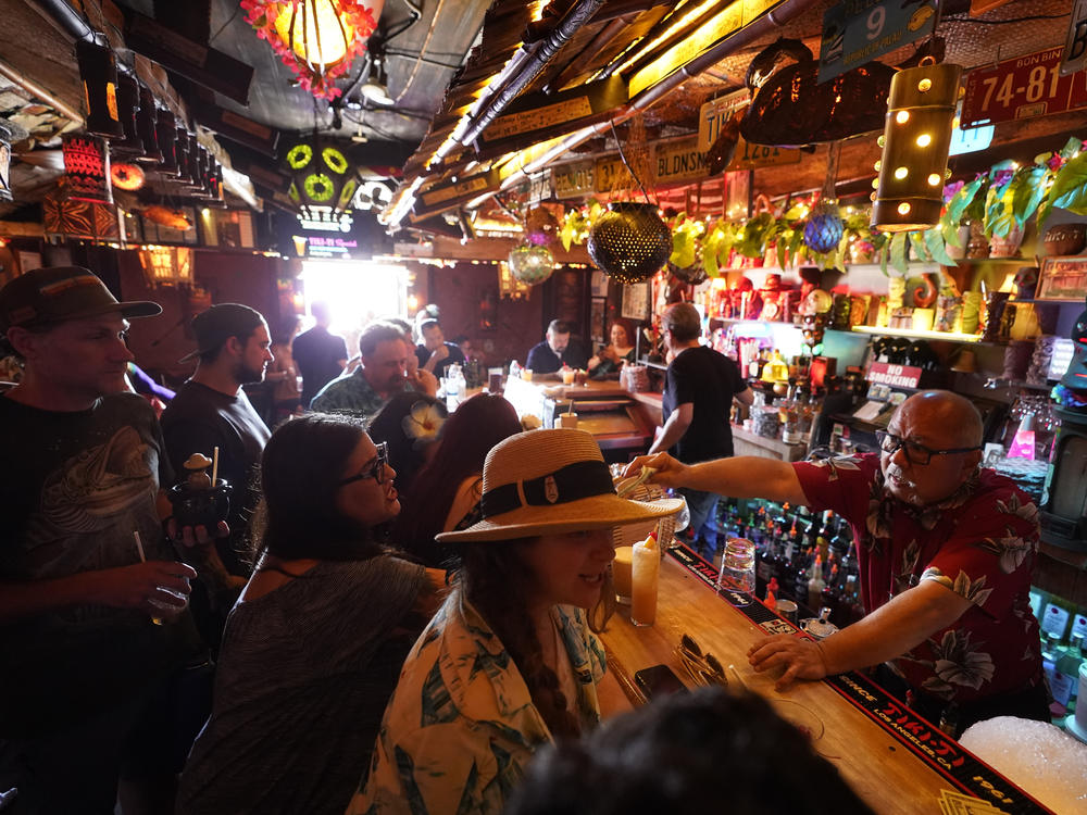 In this Wednesday, July 7, 2021, file photo, patrons enjoy tropical cocktails in the tiny interior of the Tiki-Ti bar as it reopens on Sunset Boulevard in Los Angeles.