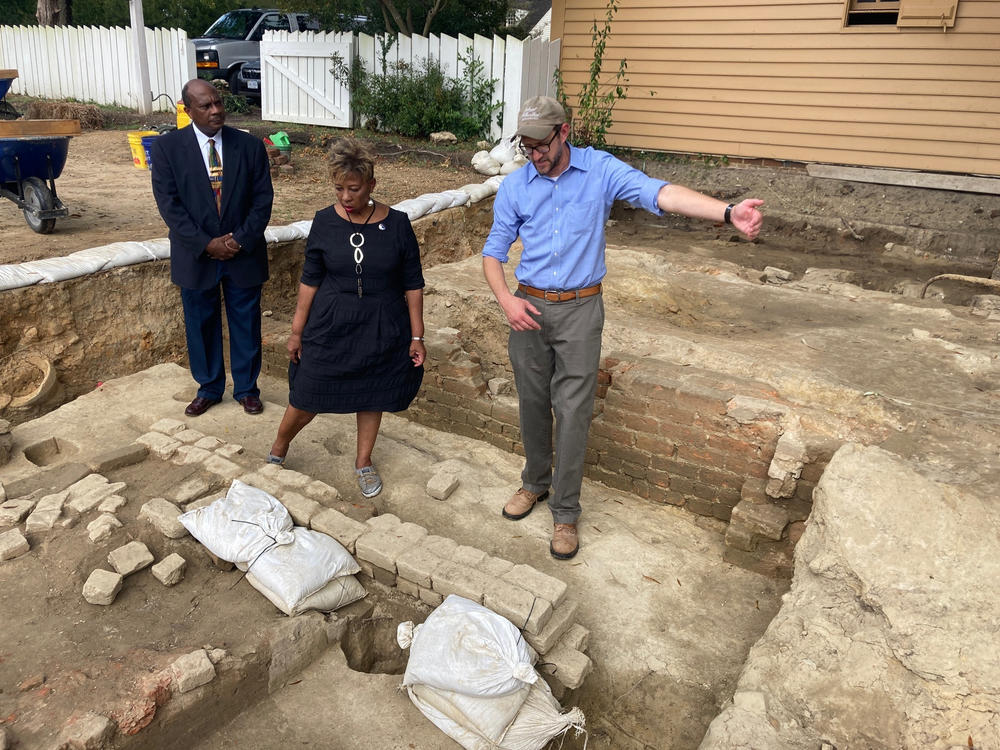 Reginald F. Davis, from left, pastor of First Baptist Church in Williamsburg, Connie Matthews Harshaw, a member of First Baptist, and Jack Gary, Colonial Williamsburg's director of archaeology, stand at the brick-and-mortar foundation of one the oldest Black churches in the U.S. on Wednesday, Oct. 6, 2021, in Williamsburg, Va.
