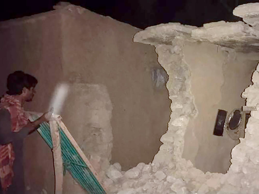 A local resident looks at his damaged house following a severe earthquake that hit the area in Harnai, about 60 miles from Quetta, Pakistan. A powerful earthquake shook parts of southwestern Pakistan early Thursday.