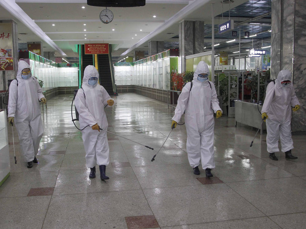In this Dec. 28, 2020, file photo, staff of the Pyongyang Department Store No. 1 disinfect the store to help curb the spread of the coronavirus before it opens in Pyongyang, North Korea.