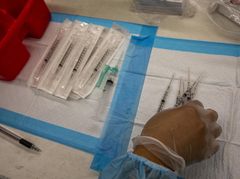 A healthcare worker prepares doses of the Pfizer-BioNTech Covid-19 vaccine at a mobile vaccination clinic at a high school in Los Angeles in August.