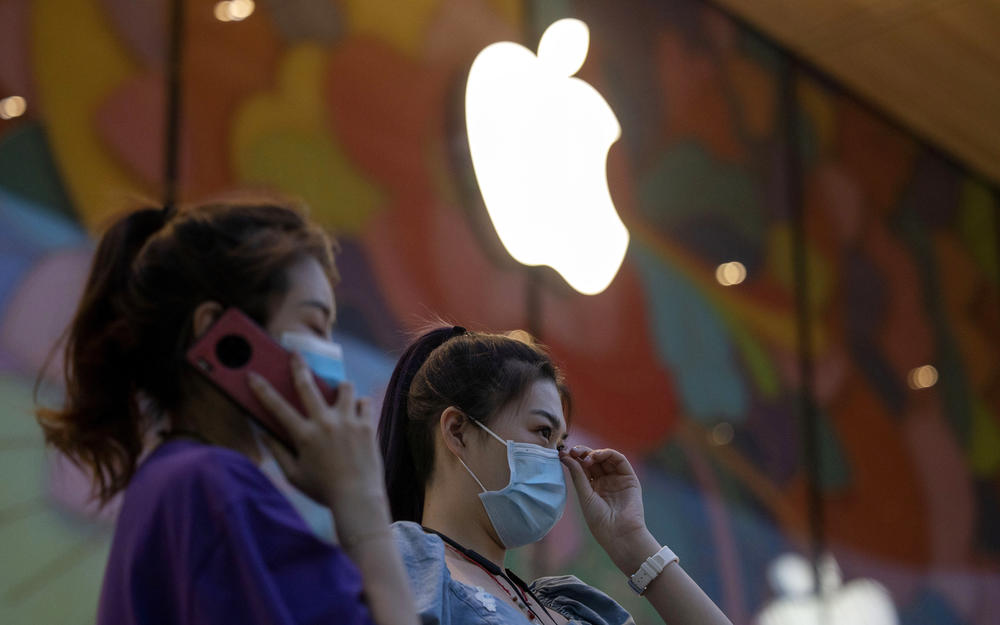 Women wait outside an Apple store as it prepared for its grand opening in Beijing in July 2020. Despite increased U.S.-China tensions, including trade friction, the world's two largest economies still have one of the world's largest trading relationships.