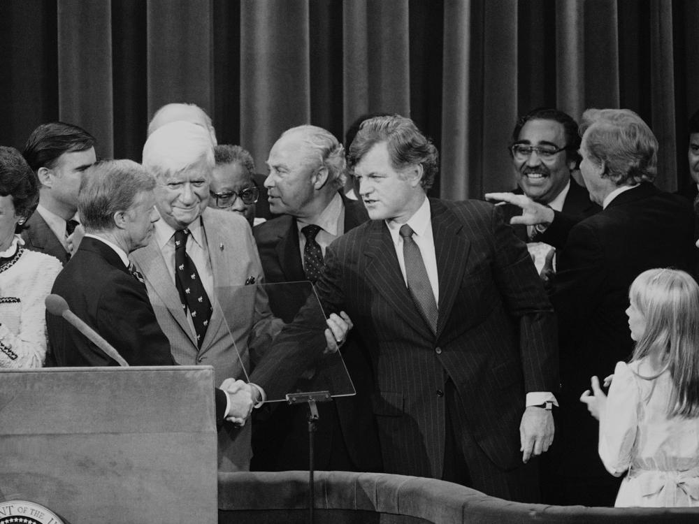 Months after his challenge to the incumbent President Carter had failed, Sen. Edward Kennedy (D-Mass.) makes a belated gesture of unity in the closing moments of the 1980 National Convention.