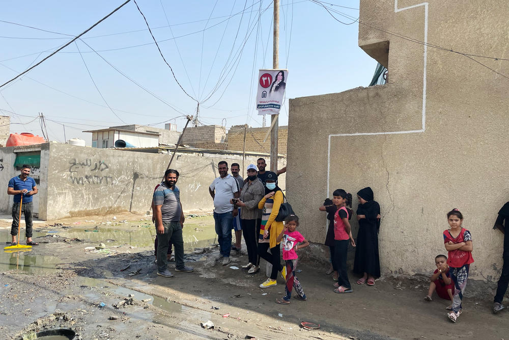People stand on a street corner in a poor Baghdad neighborhood called Basateen. After the U.S. invasion in 2003, Washington backed the establishment of a governing structure in Iraq designed to share power among the country's different religious sects. But this has reinforced patronage and inefficiency in government, and a deteriorating quality of life for Iraqi citizens.