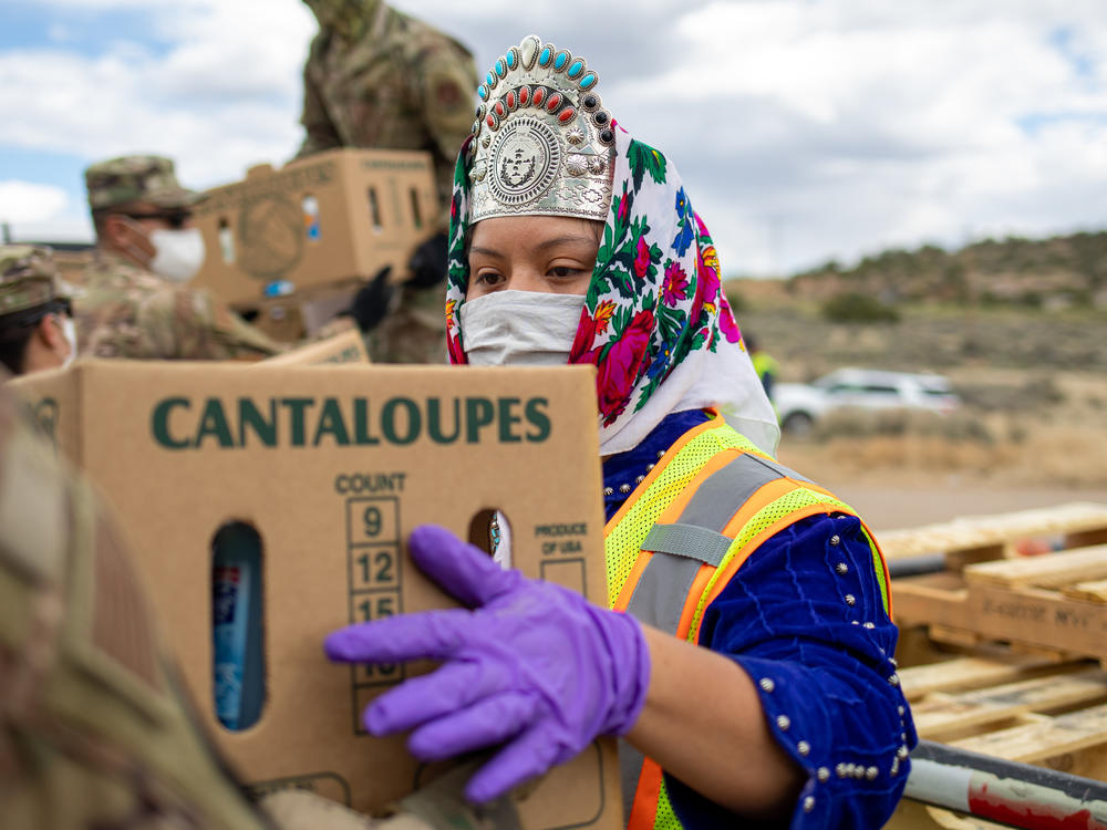 Shaandiin Parrish, who was then Miss Navajo Nation, grabs a box filled with food and other supplies to distribute to Navajo families on May 27, 2020, in Counselor on the Navajo Nation Reservation, New Mexico.