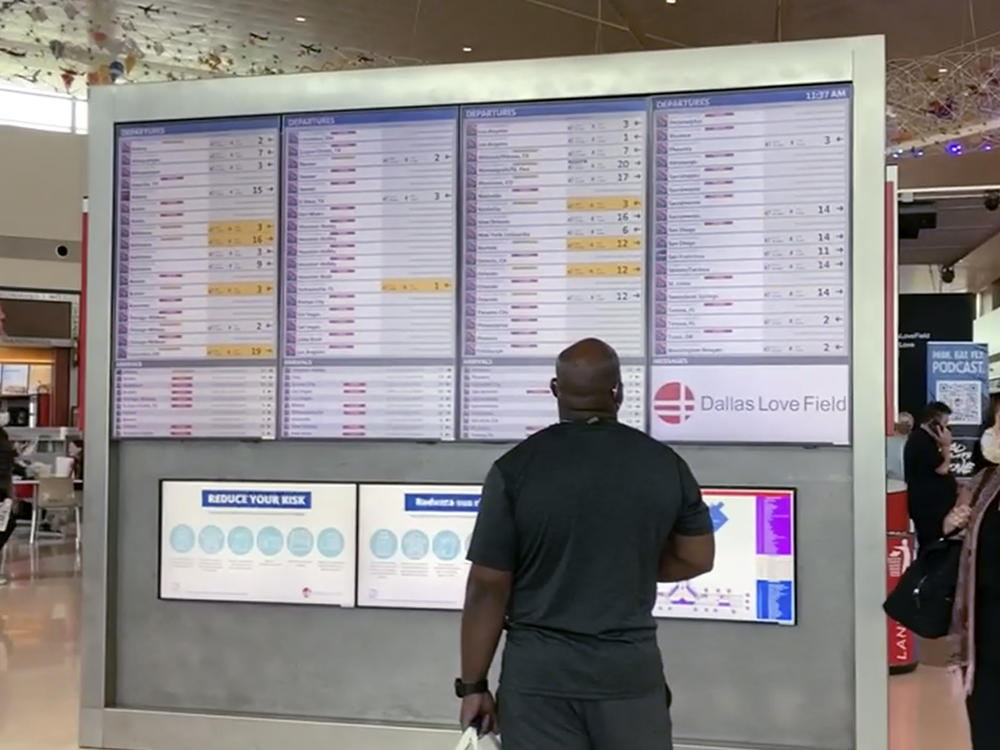 Passengers look for information on their flights on Sunday, as Southwest Airlines canceled hundreds of flights over the weekend, blaming the woes on air traffic control issues and weather.