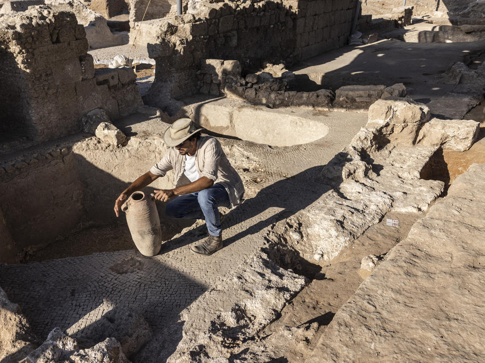 Avshalom Davidesko, from the Israel's Antiquities Authority, examines a jar in a massive ancient winemaking complex dating back some 1,500 years in Yavne, south of Tel Aviv, Israel.