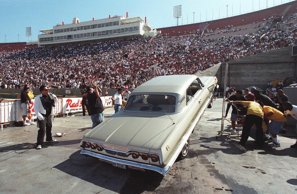 Lowriders bounce as high as possible during a car hopping contest at the Los Angeles Coliseum in 1996.