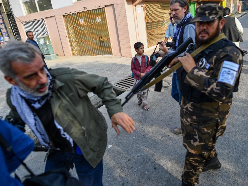 A member of the Taliban special forces pushes a journalist covering a demonstration by women protesters in Kabul on Sept. 30.