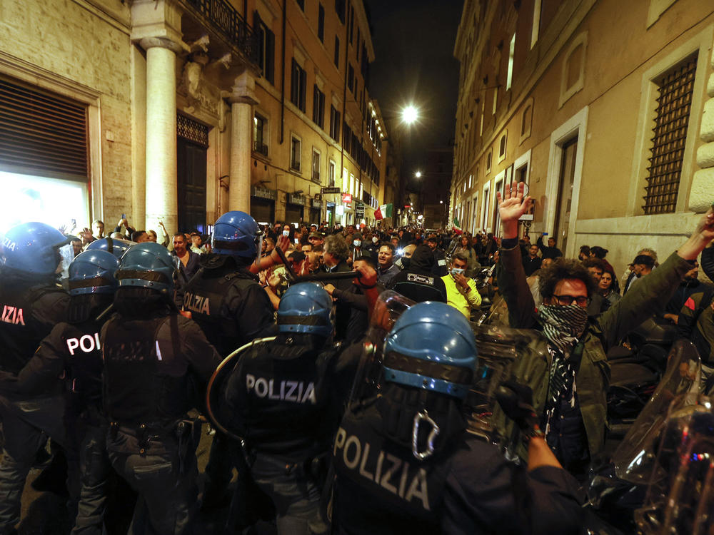 Anti-riot police officers face demonstrators trying to reach the Chigi Palace government office in Rome during a protest Saturday against green pass.