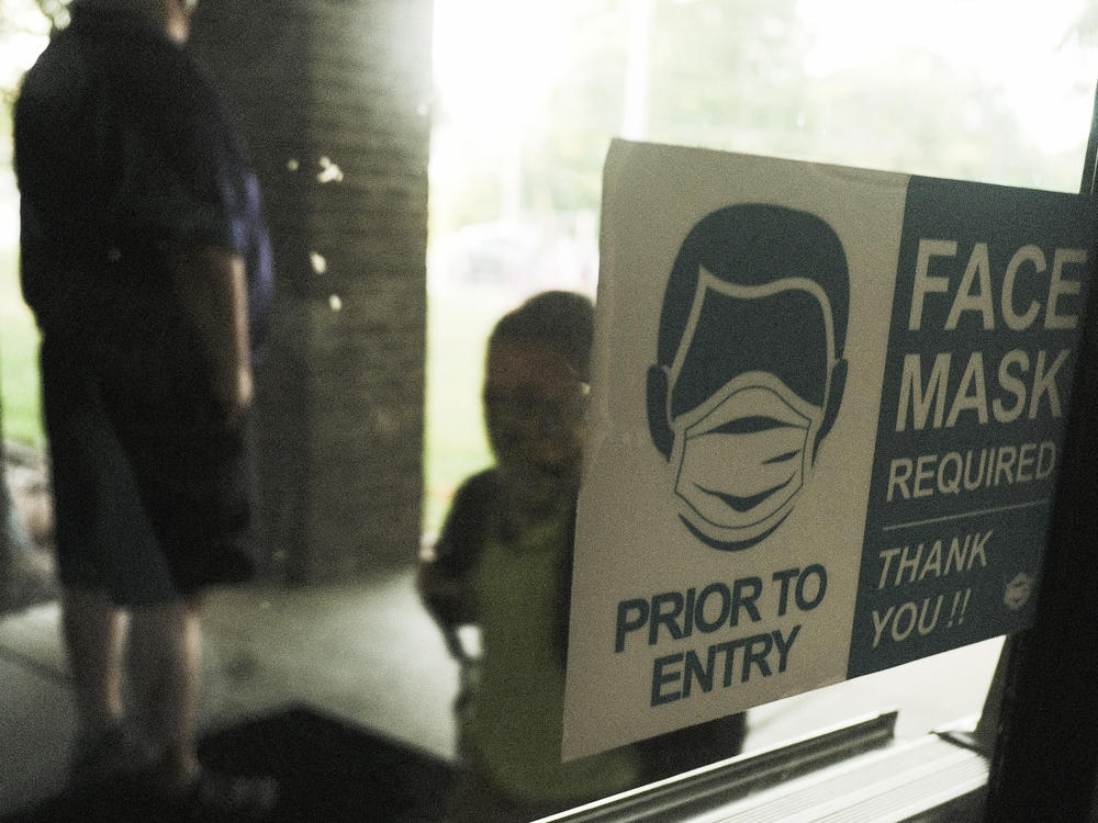 In federal lawsuits, parents in Wisconsin are blaming school districts for coronavirus infections, saying they should not have ended mask requirements during a pandemic. Here, a student in Michigan is seen arriving at school in late August.