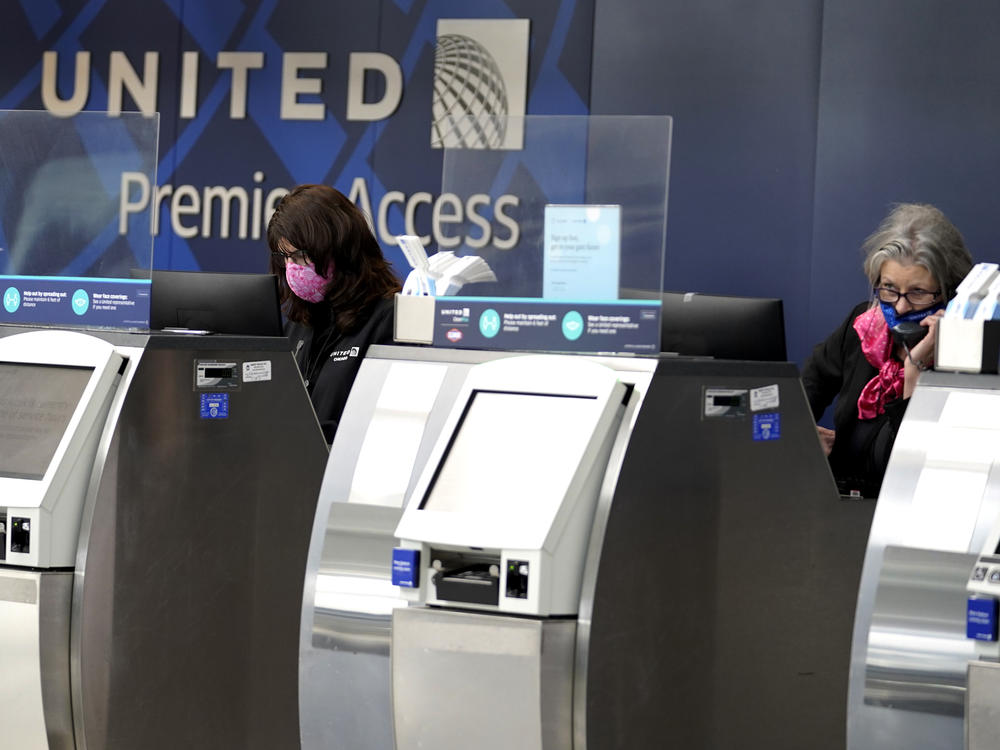 In this Oct. 14, 2020 file photo, United Airlines employees work at ticket counters in Terminal 1 at O'Hare International Airport in Chicago.