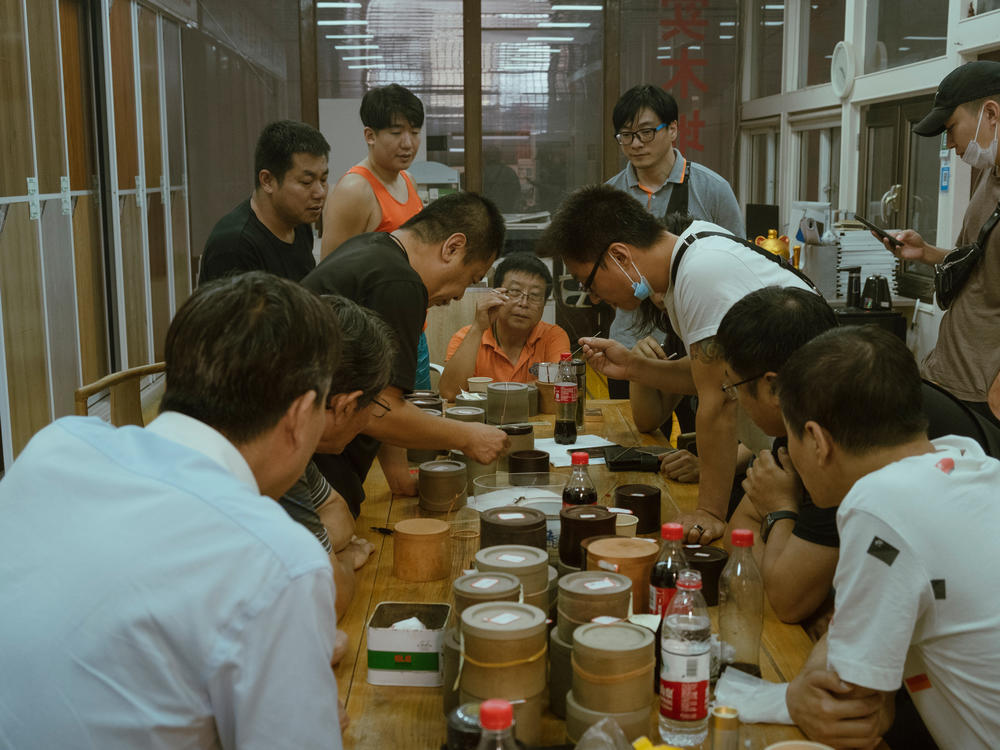 Men crowd over a cricket fight in Beijing in September. Competitive cricket fights are believed to have been held for more than 1,000 years in China.