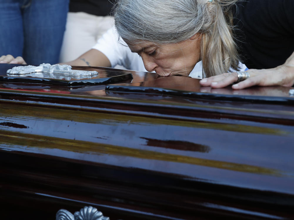 Patricia Nasutti, mother of Ursula Bahillo, who was found in a field stabbed to death kisses the coffin that contains her daughter's remains, at the cemetery during a burial service in Rojas, Argentina, on Feb. 10, 2021.