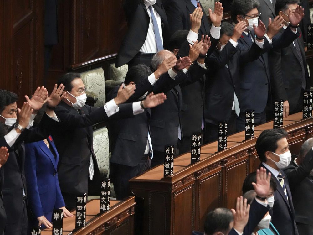 Japanese Prime Minister Fumio Kishida, forth from left, and other lawmakers give three cheers after dissolving the lower house, the more powerful of the two parliamentary chambers, during an extraordinary Diet session at the lower house of parliament Thursday.