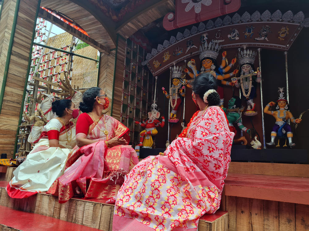 Members of Kolkata's Shubhamastu priestess group, from left to right: Sanskrit scholar Nandini, who goes by one name, Ruma Roy and Paulomi Chakraborty. The priestesses spoke to NPR at a stage set up in downtown Kolkata, where they are officially taking part in India's Durga Puja festival this week for the first time.