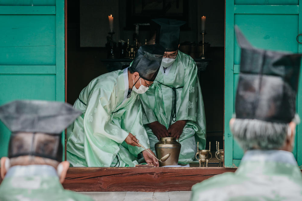 Men pour a drink during the spring ceremony at Museong Seowon.