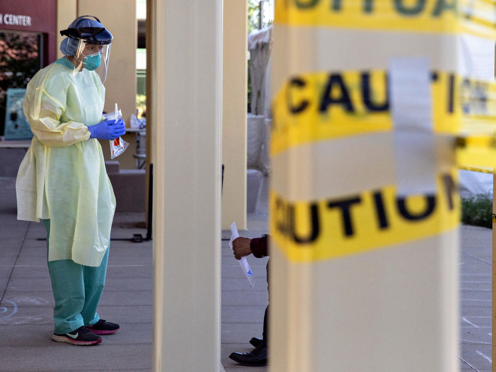 A doctor stands at a walk-up coronavirus testing site at West County Health Center in San Pablo, Calif., in April 2020. Pandemic burnout has affected thousands of health care workers.