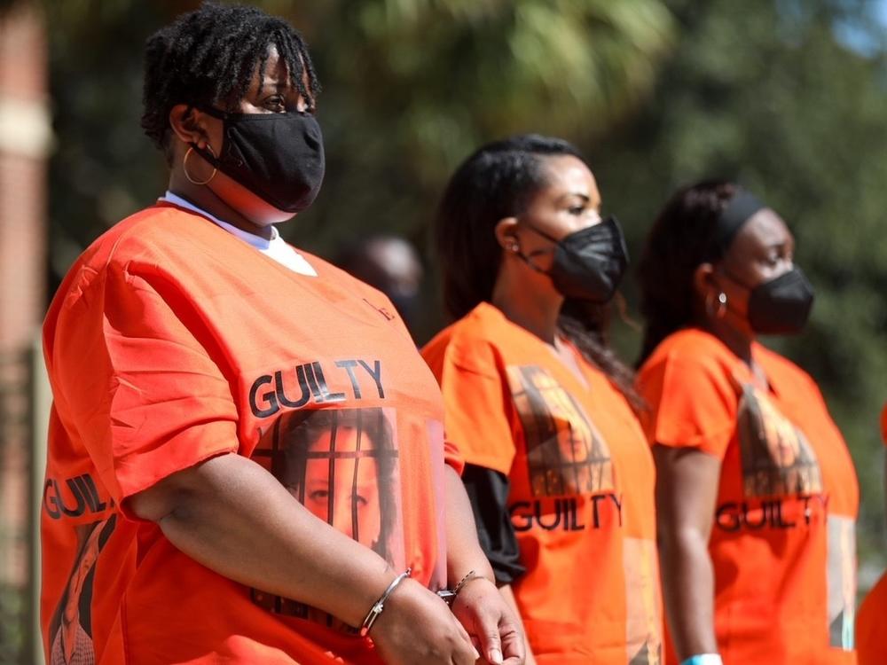 Outside of the Glynn County Courthouse, Ahmaud Arbery's aunt, Thea Brooks, joins a group during a demonstration calling for the conviction of the three men who face charges in the death of Ahmaud Arbery and other county officials they say were complicit in his death.