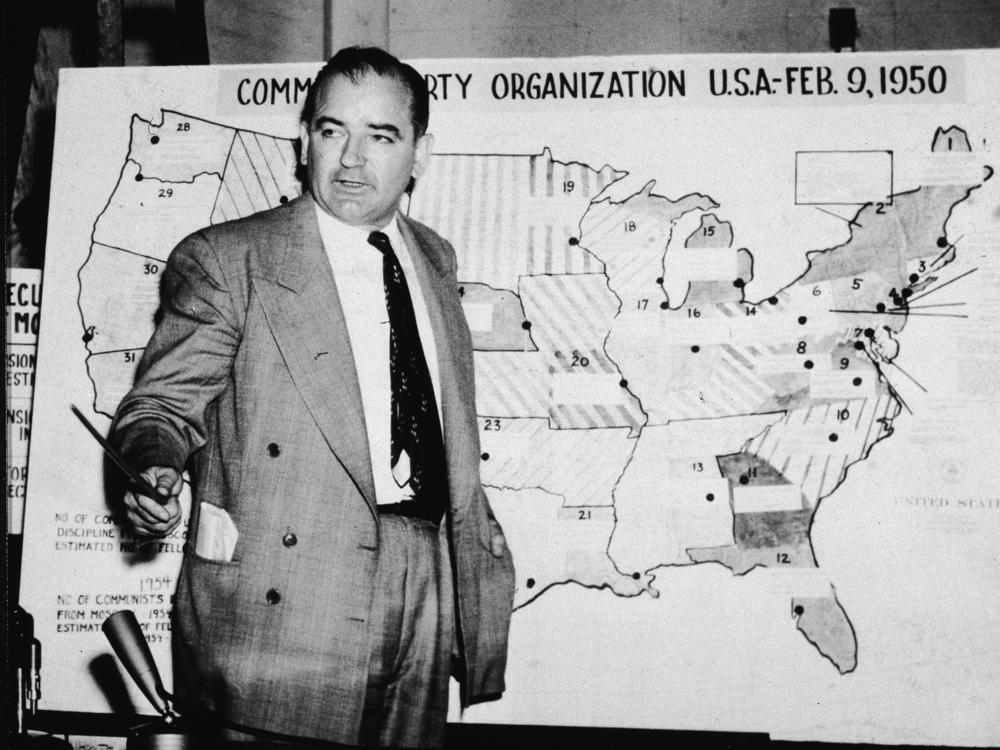 Sen. Joe McCarthy, R-Wis., testifies during hearings in Washington, D.C., on June 9, 1954. McCarthy stands before a map that charts alleged communist activity in the United States.