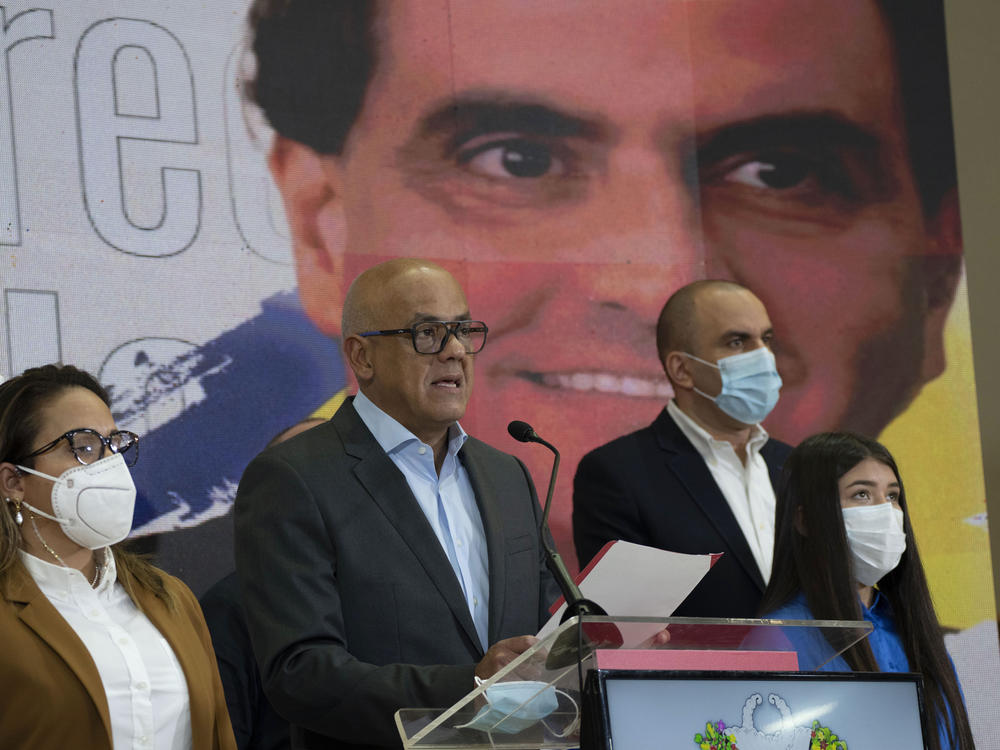 Venezuelan President of the National Assembly Jorge Rodriguez, center, speaks to the press as an image of Colombian businessman and Venezuelan special envoy Alex Saab is in the back in Caracas, Venezuela, Saturday, Oct 16, 2021.