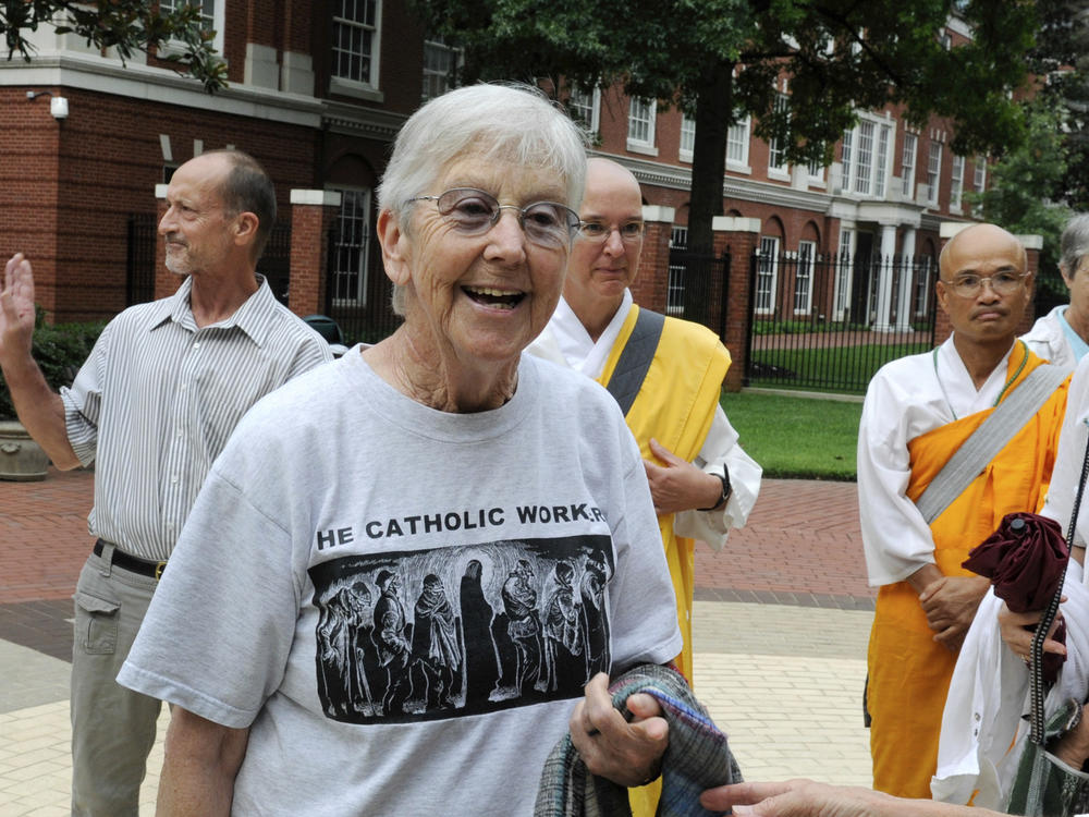 Sister Megan Rice, center, and Michael Walli, in the background waving, are greeted by supporters in 2012 as they arrive for a federal court appearance in Knoxville, Tenn., after being charged with sabotaging a government nuclear complex. Rice died on Oct. 10 in Rosemont, Pa. She was 91.